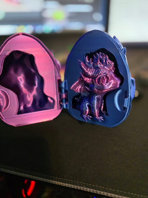 Front view of 3D printed dragon egg locket open with detailed baby dragon and pink interior lining